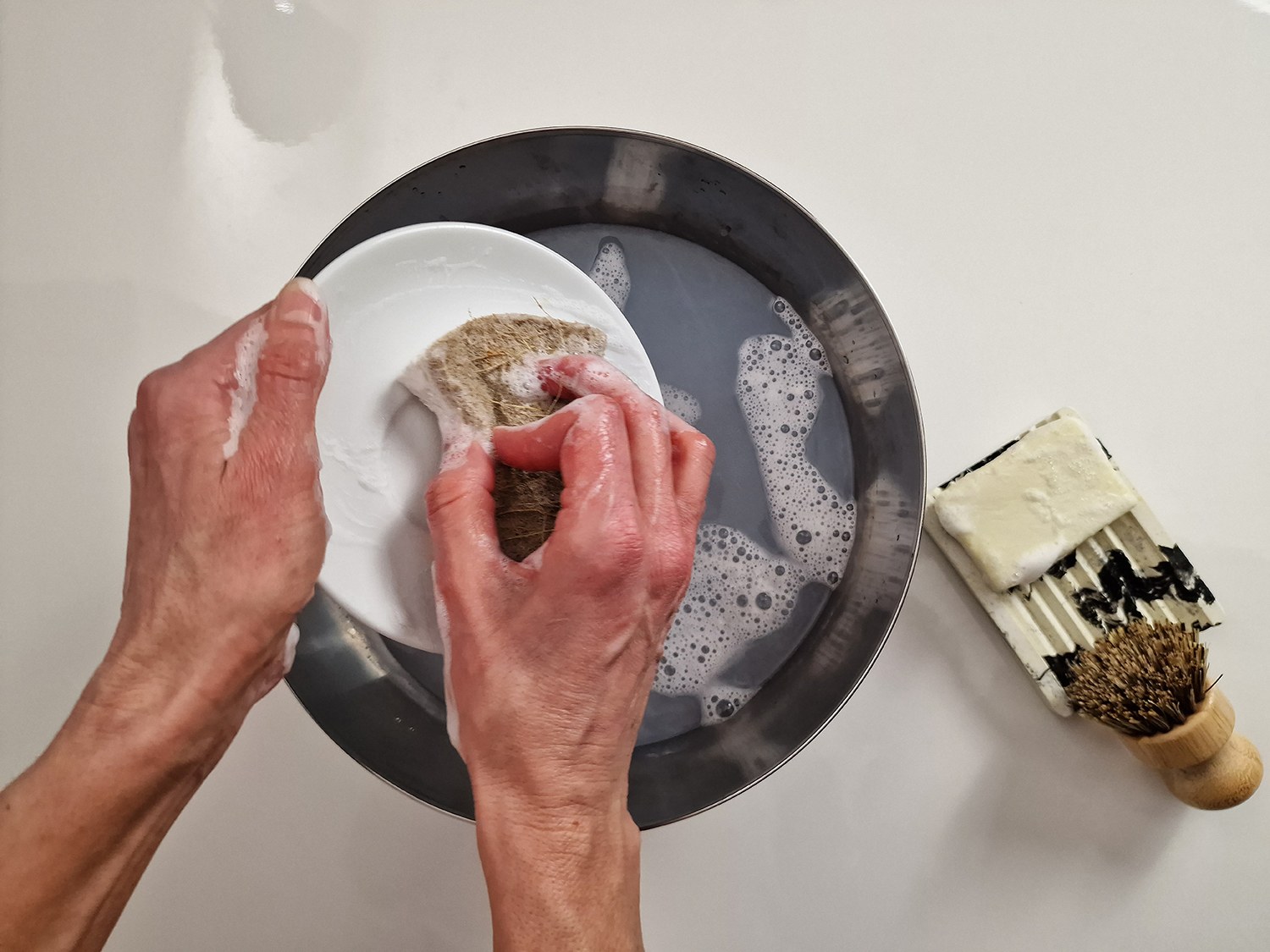 Vierka spült Geschirr mit der festen Spülseife, die sie selbst aus Rohstoffen von Handymade hergestellt hat.